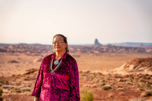 A Portrait Of A Native American Navajo Woman In Her Native Dress And Turquoise Jewelry With The Shiprock Monument, Near Kayenta, Arizona In The Background A Portrait Of A Native American Navajo Woman In Her Native Dress And Turquoise Jewelry With The Shiprock Monument, Near Kayenta, Arizona In The Background hopi culture photos stock pictures, royalty-free photos & images