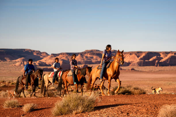 четыре молодых коренных американцев навахо братья и сестры верхом на лошадях bareback в северной аризоне долина монументов племенной парк в су - bareback стоковые фото и изображения