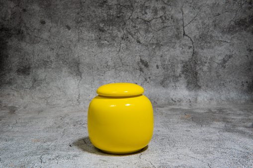 The yellow decorative plastic jar with cover on white