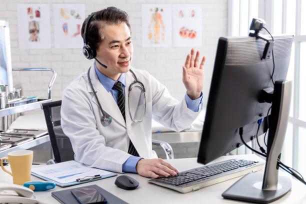 Telemedicine concept - doctor part Telemedicine concept -  asian senior male doctor say hi to patient on the internet and make a discussion in clinic by webcam one mature man only audio stock pictures, royalty-free photos & images