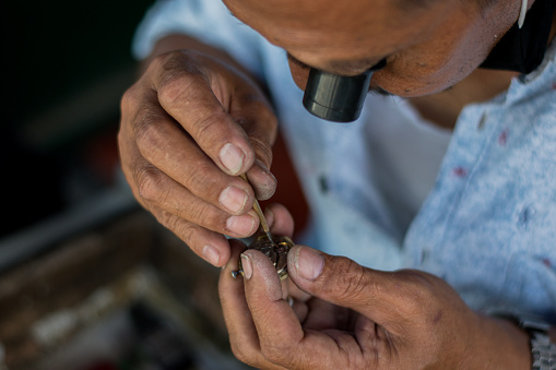 Jakarta, Indonesia - October 24, 2020: The technician is repairing of mechanical wristwatch at Senen market in Jakarta. Selective focus.