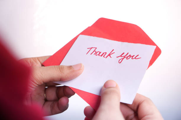 istock women's hand holding thank you note isolated on white 1282605776