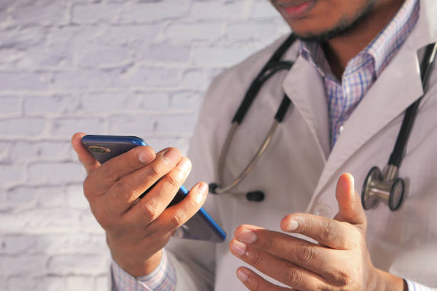 istock close up of doctor hand using smart phone indoor 1282605944