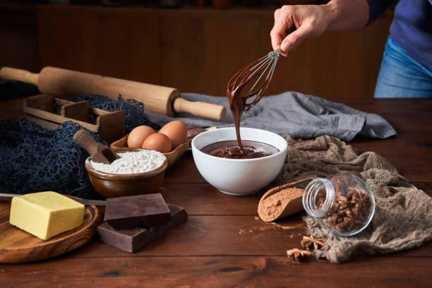 istock Woman hands making chocolate mousse and cookies on a wooden table in a rustic kitchen 1282608498