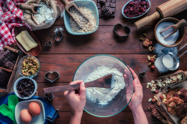istock Young woman hands mixing ingredients for chocolate and nuts cookie making 1282609309