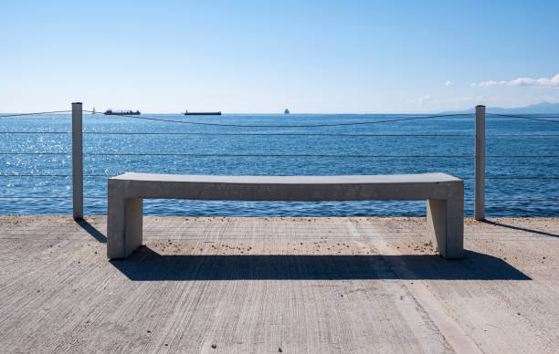 istock Empty bench on concrete deck, sea view, blue sky background. 1282613219