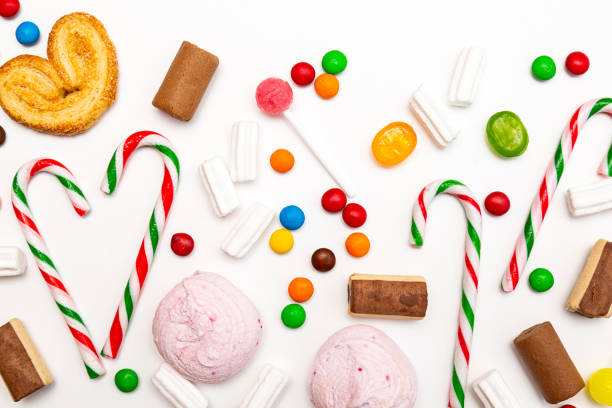 istock Various colored sweets on a white background. Lollipops, caramel, candy canes, marshmallows, chocolate, cookies top view 1282618299