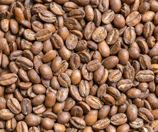 Texture of medium - light roasted coffee beans. Top view.