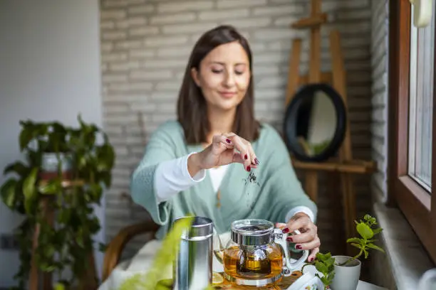 Young Woman preparing her winter tea and welcoming new day