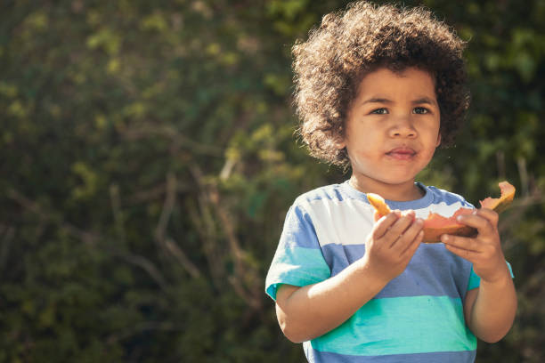 istock Cute boy eating a papaya on a sunny day 1282631479