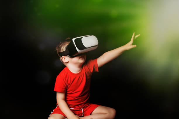 istock Small Boy experiencing virtual reality on black background with light luminous effects 1282635920