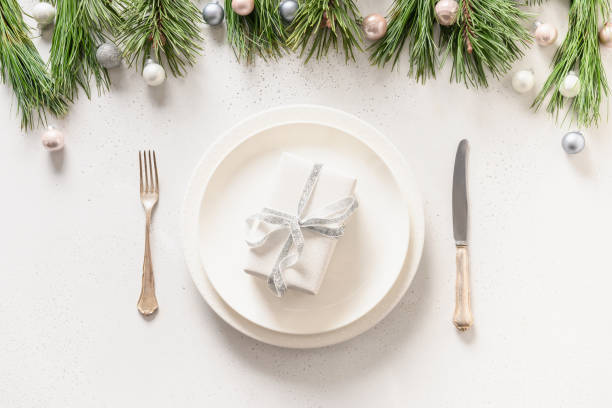 istock Christmas table setting with white holiday elegant decorations on white table. View from above. 1282637870