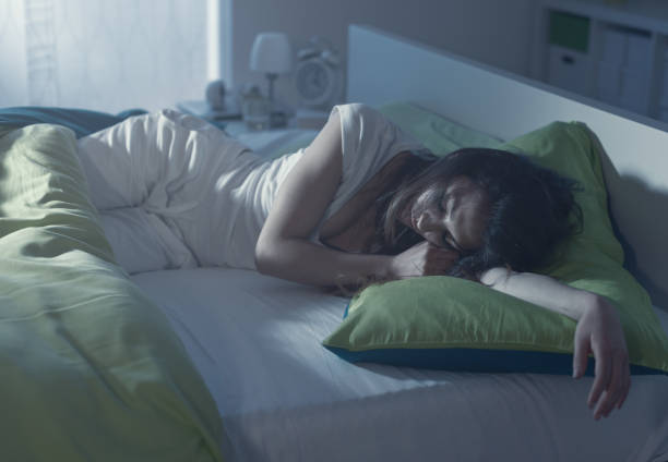 Woman sleeping in her bed Young woman sleeping in her bed at night and lying on her arm young hot stock pictures, royalty-free photos & images