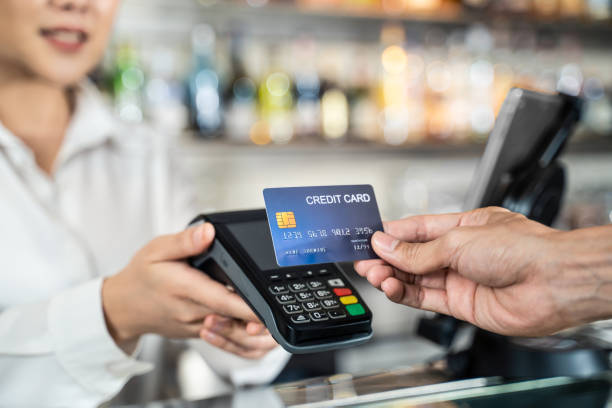 primo piano colpo della mano del cliente utilizzando carta di credito fittizia per il pagamento alla cameriera presso la cassiera nel ristorante del bar, denaro senza contanti e concetto di tecnologia di pagamento con carta di credito. - spending money foto e immagini stock