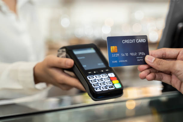 fermez-vous vers le haut de la main de client utilisant la carte de crédit factice pour le paiement à la serveuse au caissier dans le restaurant de café, l’argent cashless et concept de technologie de paiement de carte de crédit. - point de vente photos et images de collection