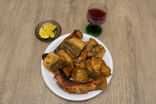 Fried fish on a plate with glass of red wine stock photo