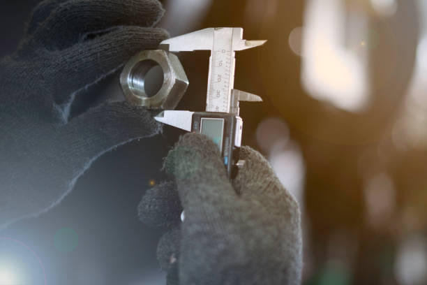 istock Hand of technician wearing cloth gloves was using a digital Vernier tool to measure the width of the nut. 1282643854