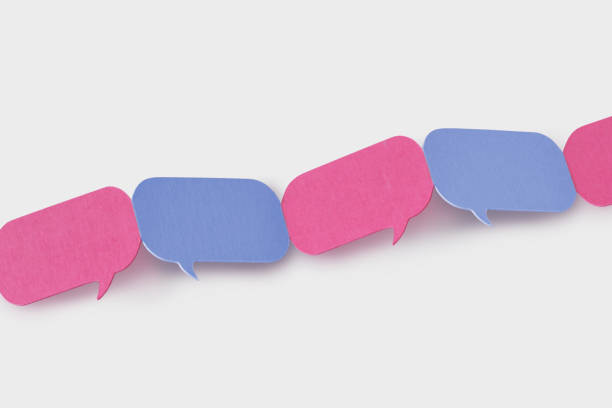 istock Pink and blue speech bubbles linked together in a chain - Concept of communication between men and women (gender communication) 1282643888