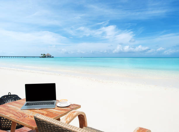 istock Mobile work office on the sunny beach with blank laptop screen 1282646374