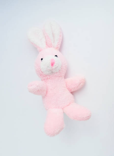istock pink rabbit soft toy on a light solid background 1282647752