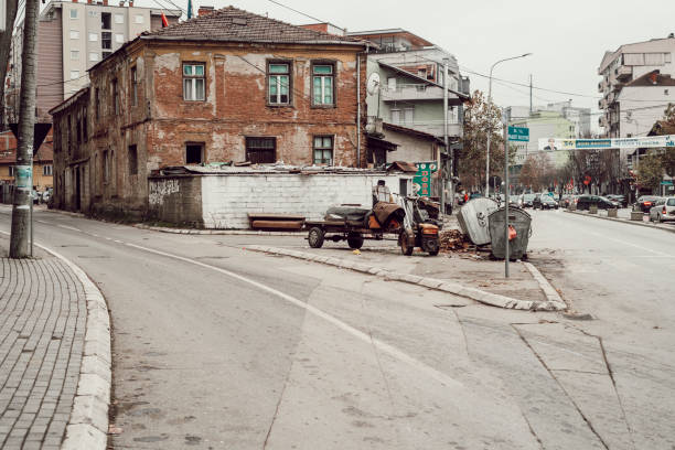 Mitrovica, one of the main cities of Kosovo, is currently traversed by political and social tensions which represent the result of the choice, made by Kosovo, to declare its unilateral independence from Serbia in February 2008. The population of Mitrovica is mostly of Albanian origin and of Muslim religion, while the minority is of Serbian origin and Orthodox religion. The city is literally split in two. In this image, part of a reportage made in November 2017, you can see a street that crosses the Albanian part of the city. The poverty of the houses and the condition of its communication routes reflects the general poverty of the Balkan country.