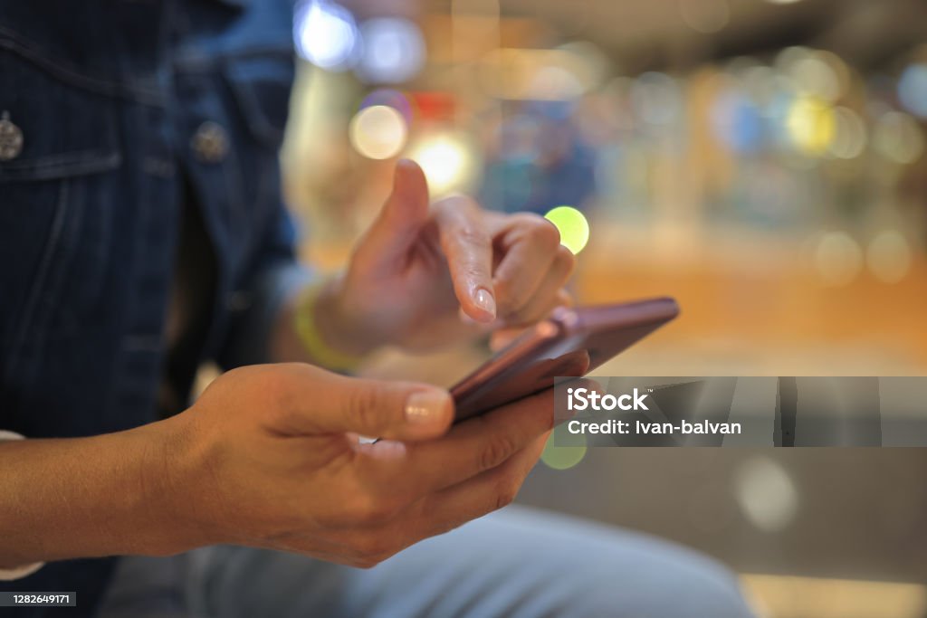 Woman's hand holds smartphone and moves her finger across screen. Woman's hand holds smartphone and moves her finger across screen. Modern technologies in everyday life concept Cyborg Stock Photo