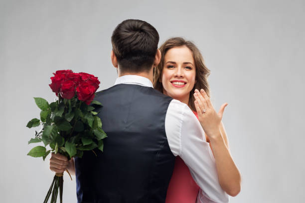 istock woman with engagement ring and roses hugging man 1282652625
