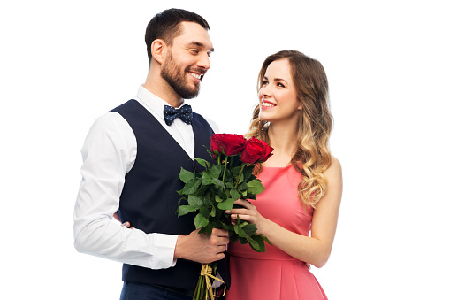 valentines day, relationships and people concept - happy couple with bunch of flowers hugging