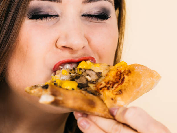 istock Woman eating hot pizza slice 1282652836