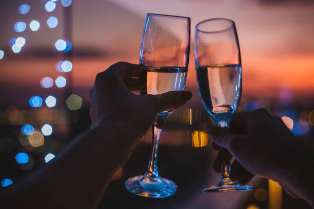 Drink for us Hands holding glasses of champagne , city in sunset in background new year urban scene horizontal people stock pictures, royalty-free photos & images