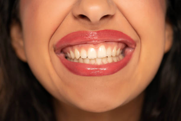 Close up view of the lower face of a young man with lips ajar and light stubble on his chin and upper lip