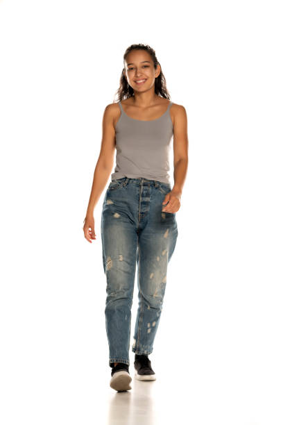 istock Young Indian woman in jeans walking on white 1282654618