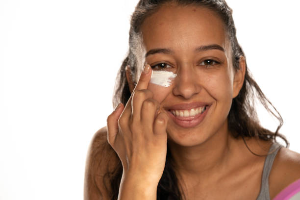 istock Young  dark skinned woman applying a creme on her  low eyelids 1282654747