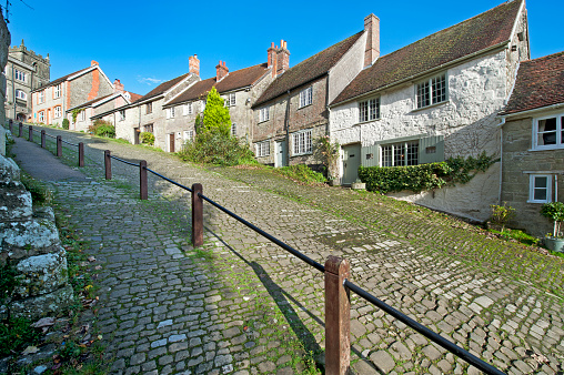 England in autumn - a sunny colourful view of Shaftesbury's ancient medieval Gold Hill, famous for featuring in the Hovis bread advertisement,  with a countryside rural landscape of rolling hills and ancient woodland that turns to a kaleidoscope of multicoloured hues as the season changes