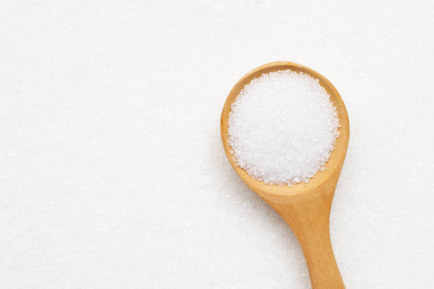 istock Wooden spoon with white granulated sugar. Top view 1282657607