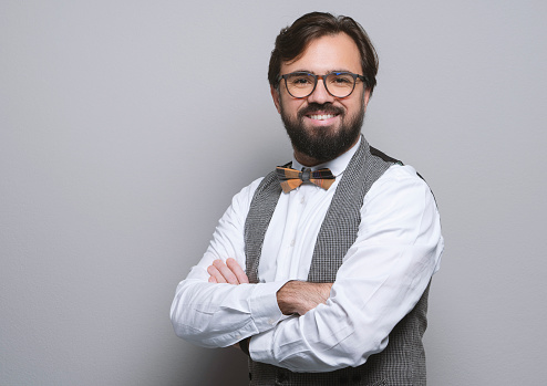 Portrait of a confident businessman over gray background. Horizontal composition, studio shot