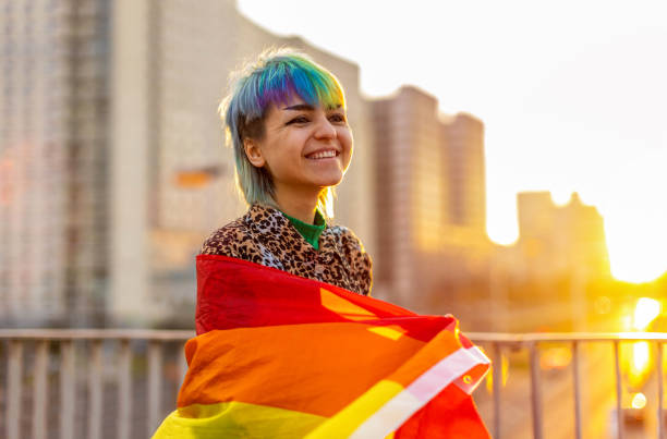 Portrait of a gender fluid person wearing rainbow flag Portrait of a gender fluid person wearing rainbow flag non binary gender photos stock pictures, royalty-free photos & images