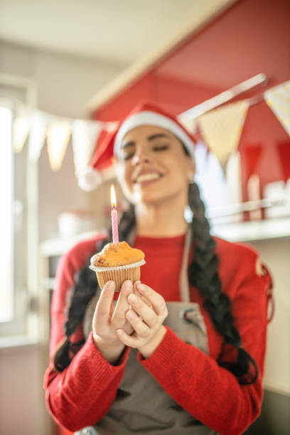 istock Beautiful lady making a wish and blowing candles on her lovely cupcake 1282662682