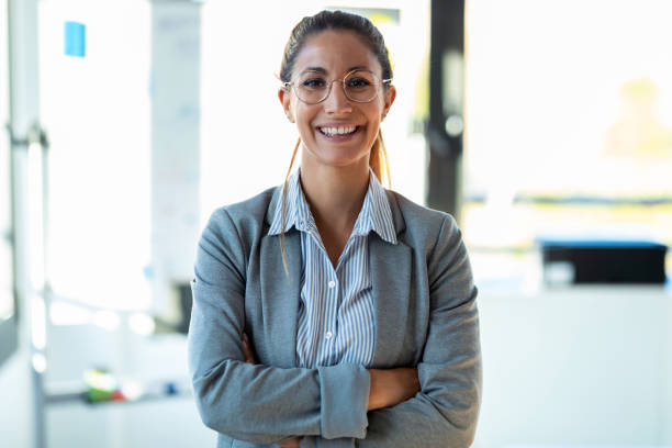 istock Smiling young businesswoman looking at camera while standing in the office. 1282662768