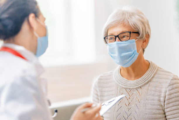 istock Doctor and senior woman wearing facemasks 1282663243