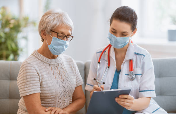 istock Doctor and senior woman wearing facemasks 1282663250
