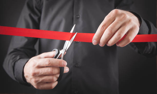 istock Man cutting red ribbon with a scissors. 1282663871