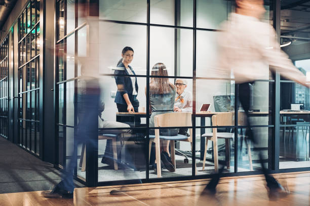 geschäftsleute, die rund um das bürogebäude spazieren gehen und arbeiten - blurred motion stock-fotos und bilder