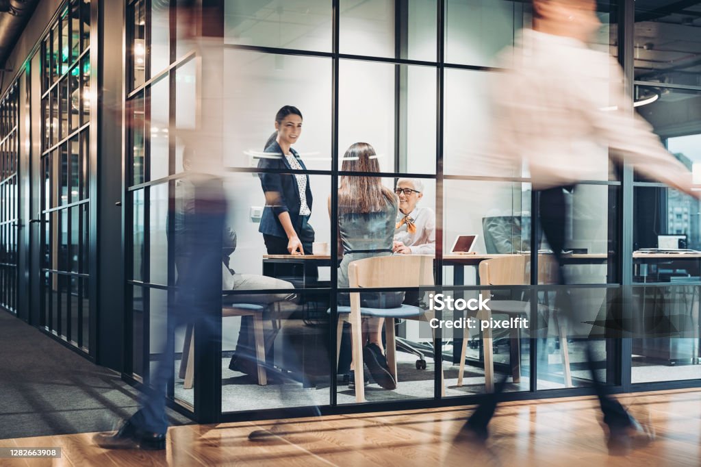 Business persons walking and working around the office building Inside view of an office building with blurred motion Office Stock Photo