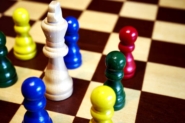 istock chess concept to diversification, colorful little pawns huddle around the big white old king 1282666421