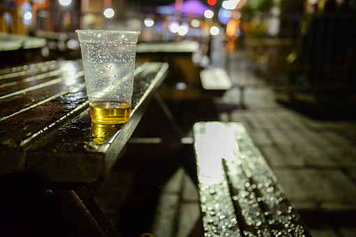An almost empty beer cup at a patio table
