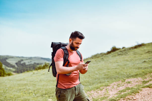 istock Latino Male Checking Smartphone Map While Hiking 1282673800
