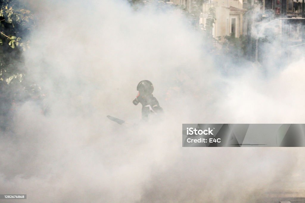 Protestor in tear gas cloud Tear Gas Stock Photo