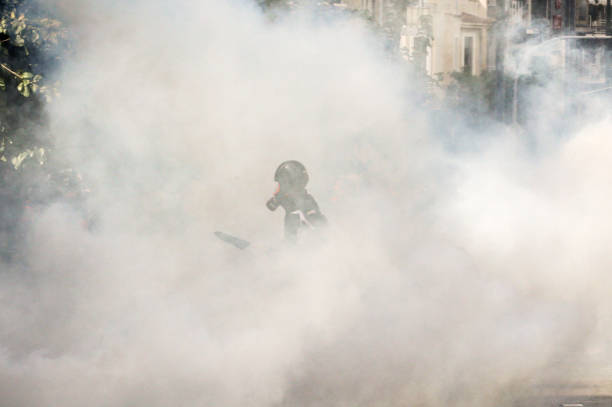 Protestor in tear gas cloud Protestor in tear gas cloud tear gas stock pictures, royalty-free photos & images