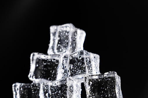 Ice cubes on black background covered with water drops. The scene is situated in controlled studio environment on black background. Photo is taken with Sony A7III camera